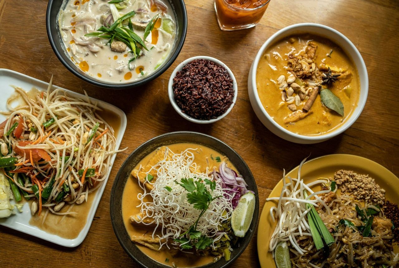 Comida tailandesa. Foto: <a href="https://unsplash.com/@alexgoesglobal?utm_source=Hoy%20Apps&utm_medium=referral" target="_blank" rel="noopener">Alexandra Tran</a> (<a href="https://unsplash.com/photos/a-wooden-table-topped-with-plates-of-food-VW0bzb90oMA?utm_source=Hoy%20Apps&utm_medium=referral" target="_blank" rel="noopener">Unsplash</a>)